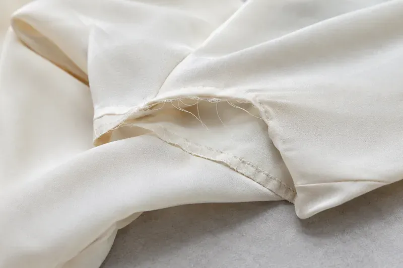 A hem that has come loose on a returned garment.